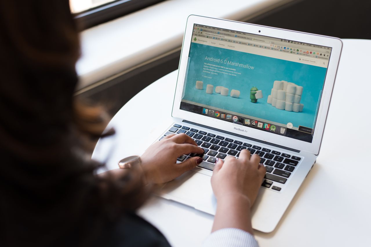 Femme d’affaires travaillant sur un ordinateur portable avec la page web Android 6.0 Marshmallow ouverte.